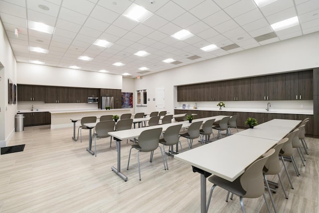 dining area with a towering ceiling and a drop ceiling