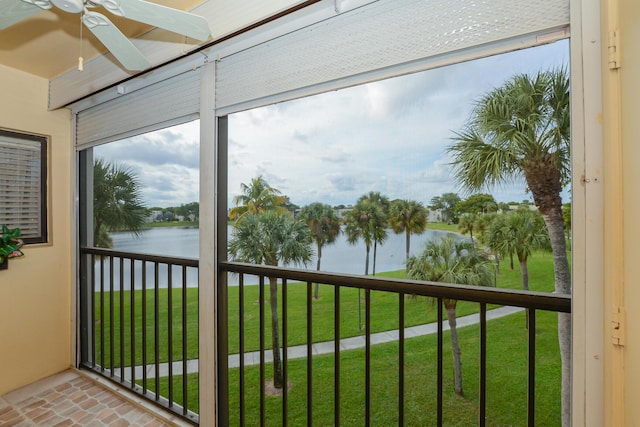 unfurnished sunroom with a water view and ceiling fan