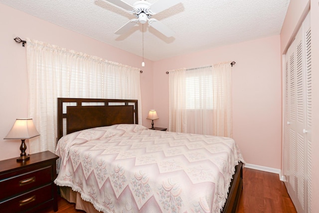 bedroom featuring ceiling fan, a closet, hardwood / wood-style floors, and a textured ceiling