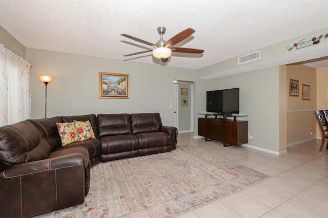 tiled living room featuring ceiling fan and a textured ceiling