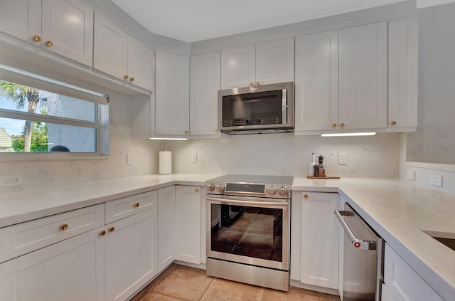 kitchen featuring white cabinets, appliances with stainless steel finishes, and backsplash