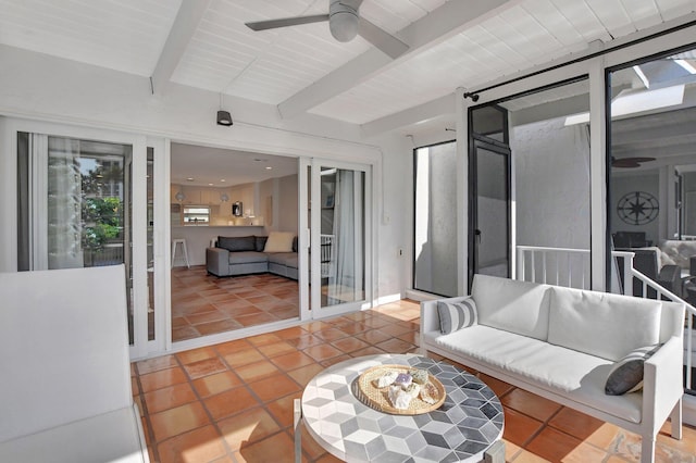 sunroom / solarium featuring ceiling fan and beamed ceiling