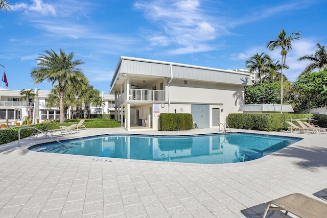 view of swimming pool with ceiling fan and a patio area