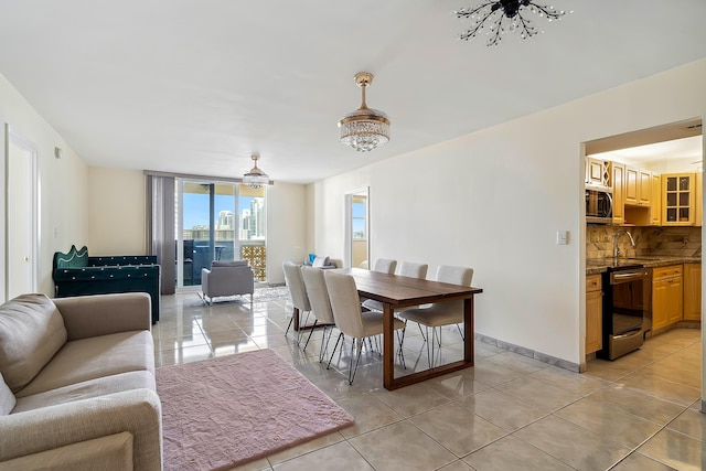 tiled dining room with sink and an inviting chandelier