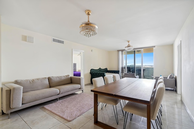 tiled dining space featuring a water view and a notable chandelier