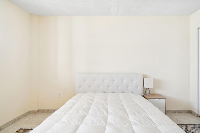 tiled bedroom featuring a textured ceiling