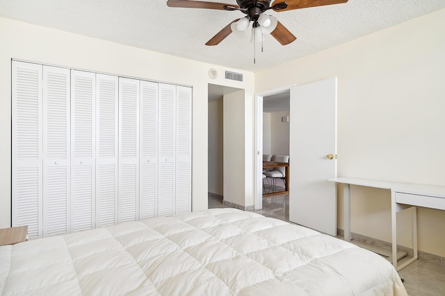 bedroom with ceiling fan, a textured ceiling, and a closet