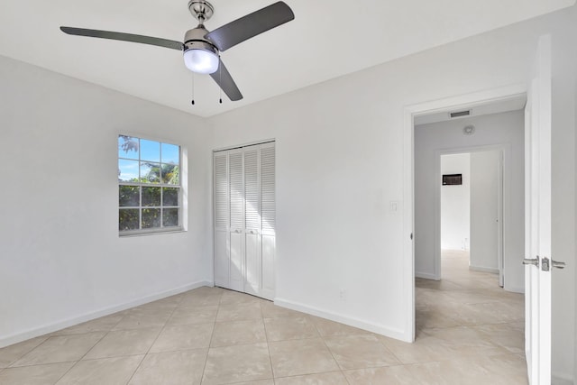 unfurnished bedroom with ceiling fan, a closet, and light tile patterned floors