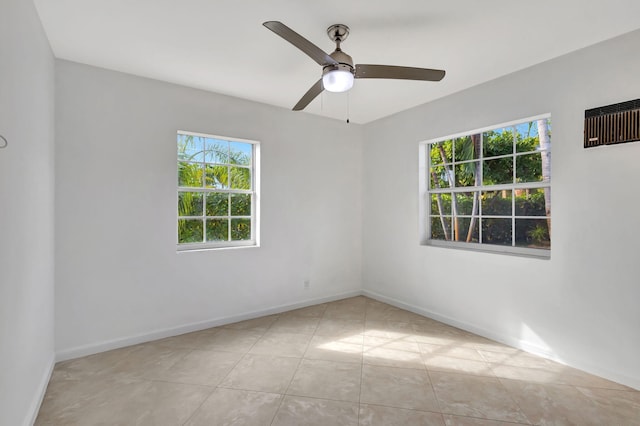 tiled empty room featuring ceiling fan and a wealth of natural light