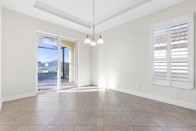 spare room with crown molding, an inviting chandelier, a raised ceiling, and light tile patterned flooring