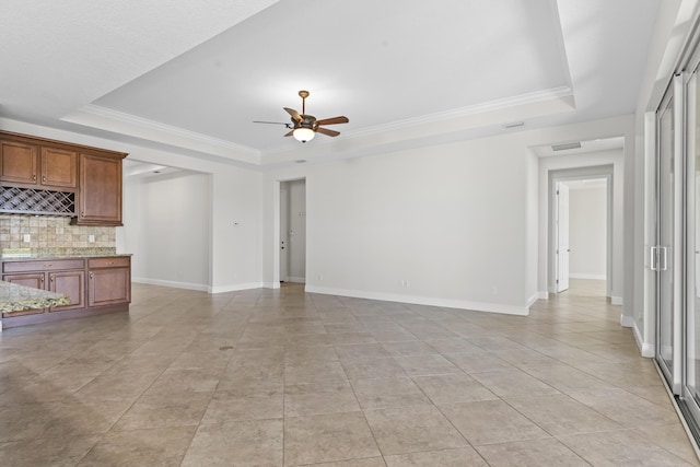 unfurnished living room featuring crown molding, light tile patterned floors, ceiling fan, and a tray ceiling