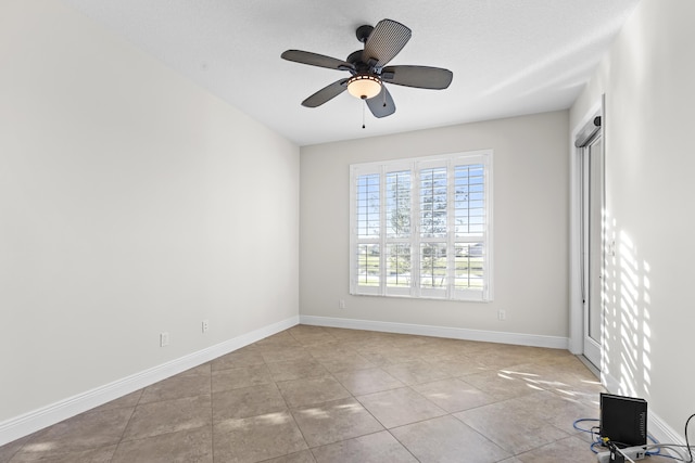 tiled spare room with ceiling fan and a textured ceiling