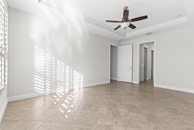 spare room featuring ceiling fan, ornamental molding, and a raised ceiling