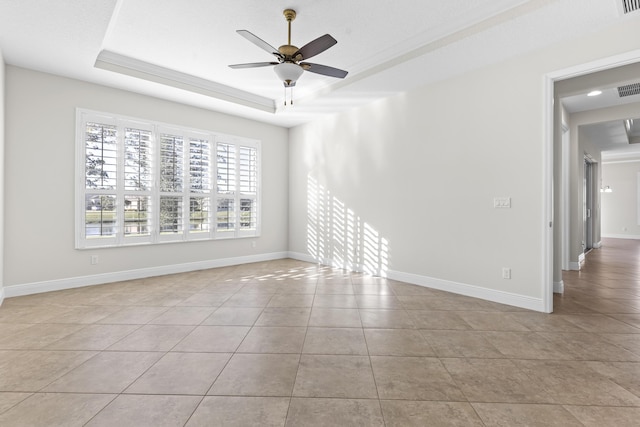 unfurnished room with light tile patterned floors, ceiling fan, and a tray ceiling