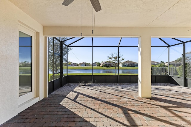 sunroom / solarium featuring ceiling fan and a water view