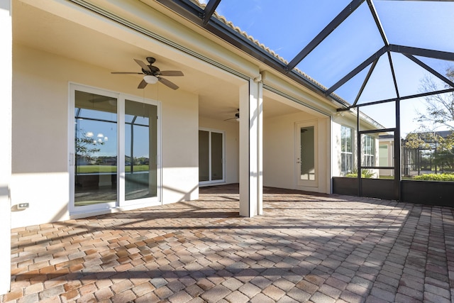 unfurnished sunroom with ceiling fan