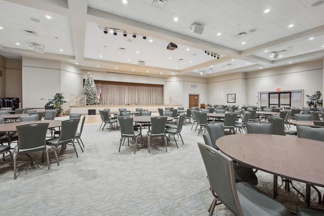 carpeted dining area featuring a high ceiling