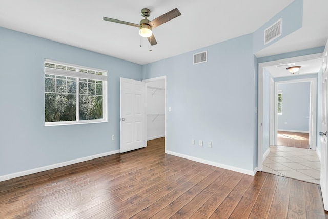 empty room with ceiling fan and hardwood / wood-style flooring