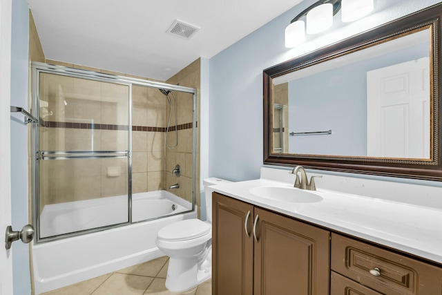 full bathroom featuring tile patterned floors, bath / shower combo with glass door, toilet, and vanity