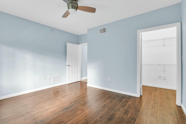 empty room with ceiling fan and dark wood-type flooring