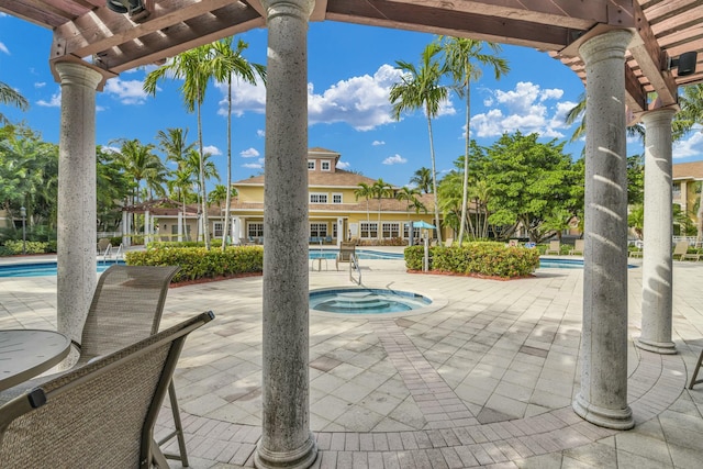 view of patio / terrace featuring a swimming pool with hot tub and a pergola