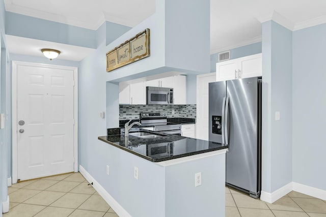 kitchen featuring tasteful backsplash, kitchen peninsula, sink, white cabinetry, and stainless steel appliances