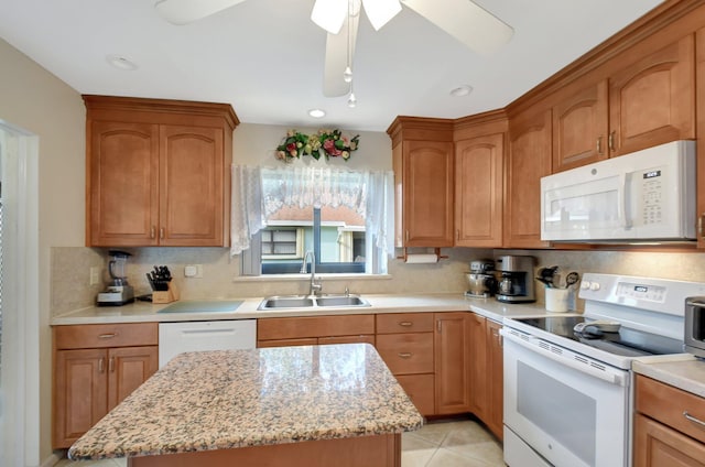 kitchen with a sink, decorative backsplash, white appliances, ceiling fan, and light stone counters