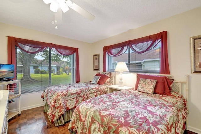 bedroom featuring parquet flooring, ceiling fan, and a textured ceiling