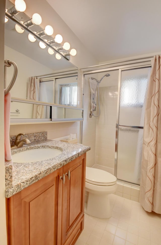 bathroom featuring vanity, tile patterned floors, toilet, and walk in shower