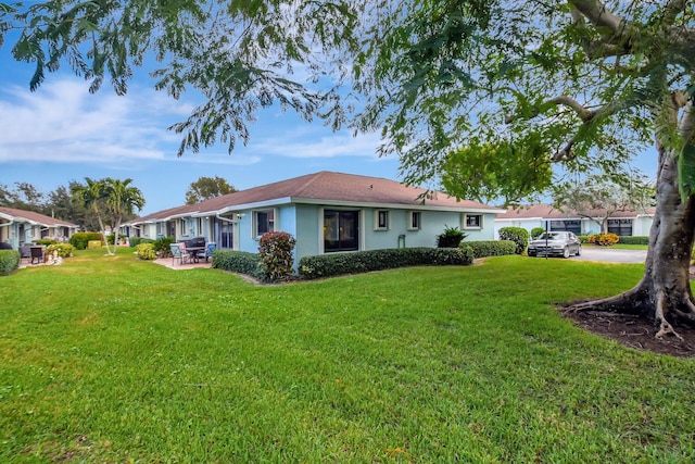 back of property with a yard and a patio