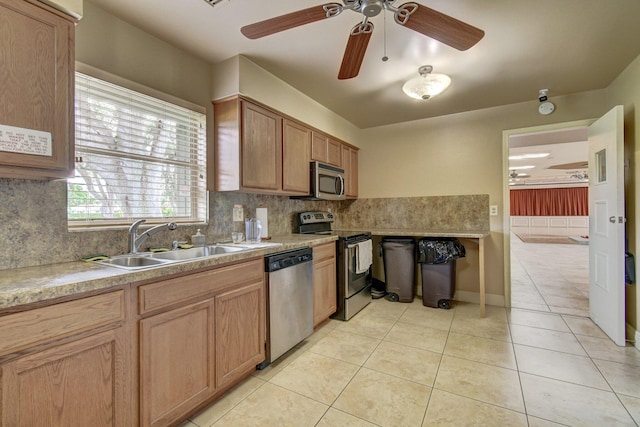 kitchen featuring a sink, light tile patterned floors, ceiling fan, backsplash, and appliances with stainless steel finishes