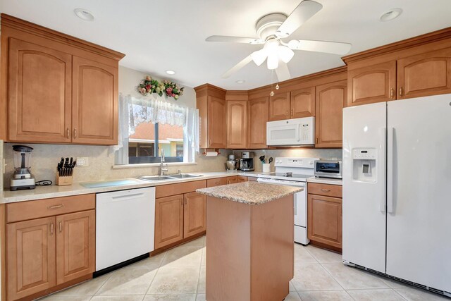 kitchen featuring a ceiling fan, light tile patterned floors, a sink, white appliances, and a center island