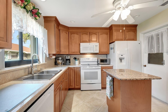 kitchen featuring sink, white appliances, ceiling fan, a kitchen island, and light tile patterned flooring