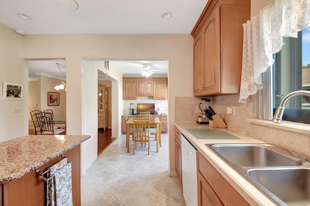 kitchen with light brown cabinetry, dishwasher, light tile patterned floors, a sink, and light stone countertops