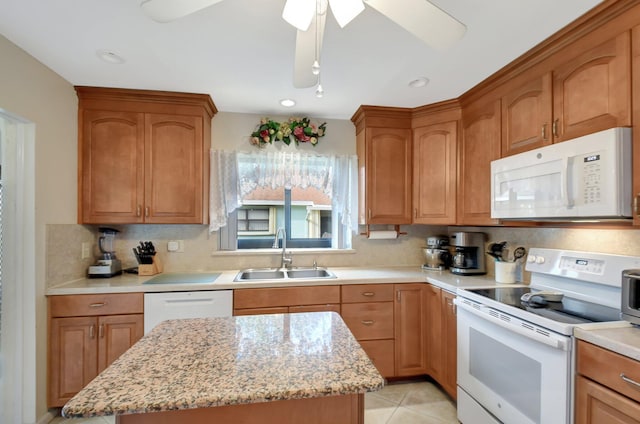 kitchen with light tile patterned flooring, a kitchen island, sink, light stone countertops, and white appliances