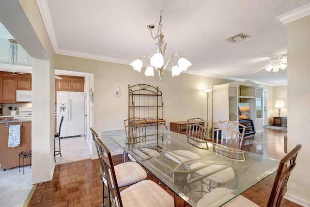 dining area featuring parquet floors, ornamental molding, ceiling fan with notable chandelier, and a textured ceiling