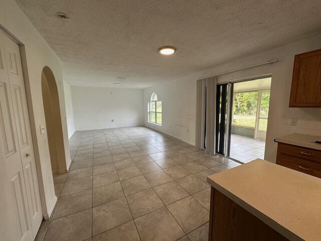 interior space featuring light tile patterned flooring and a textured ceiling