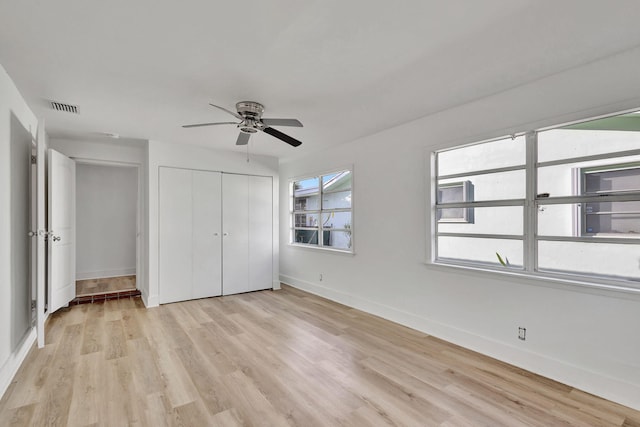 unfurnished bedroom with ceiling fan, a closet, and light wood-type flooring