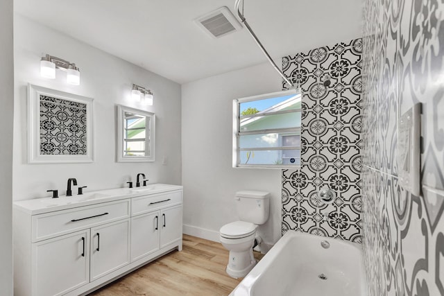 full bathroom with hardwood / wood-style floors, vanity, shower / bathtub combination, and toilet