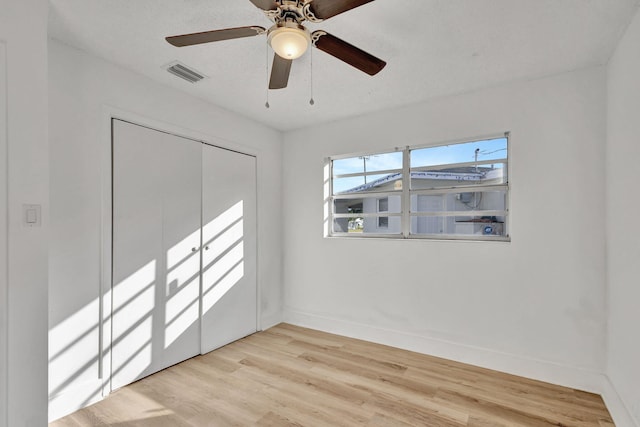 spare room with light hardwood / wood-style floors and a textured ceiling