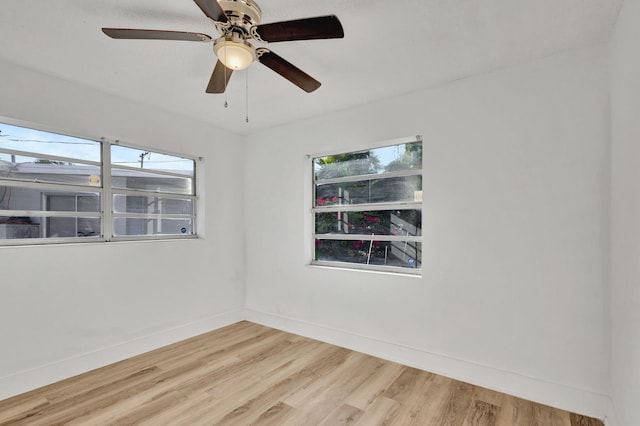 empty room featuring a wealth of natural light, ceiling fan, and wood-type flooring