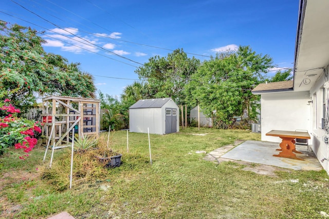 view of yard featuring cooling unit, a shed, and a patio