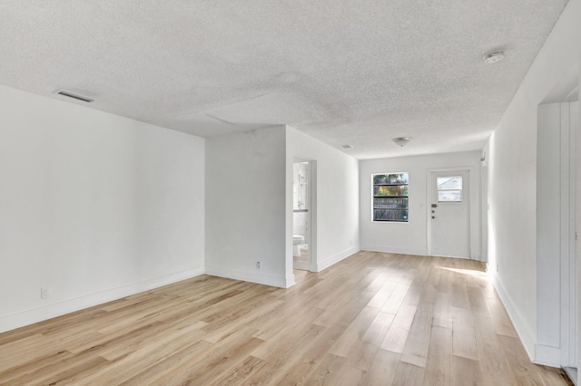 foyer featuring light hardwood / wood-style flooring and a textured ceiling