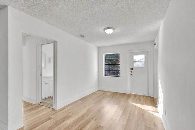 entrance foyer featuring light wood-type flooring and a textured ceiling