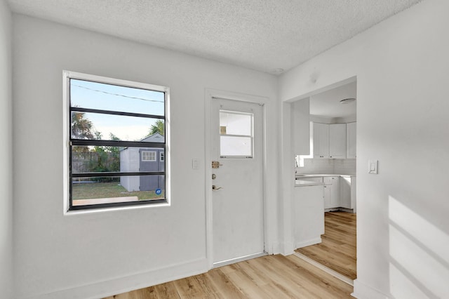 entryway featuring a textured ceiling and light wood-type flooring