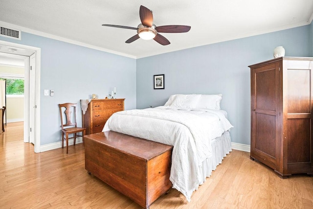 bedroom featuring ceiling fan, light wood-type flooring, and crown molding