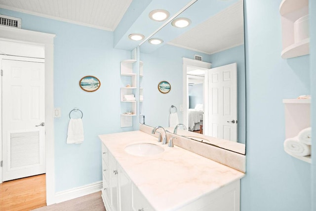 bathroom featuring hardwood / wood-style flooring, vanity, and crown molding