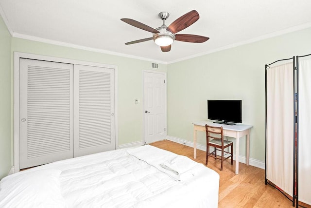 bedroom featuring hardwood / wood-style floors, a closet, ceiling fan, and ornamental molding