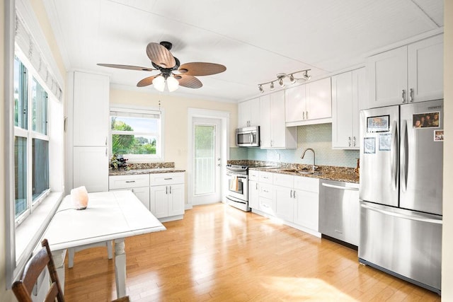 kitchen with sink, dark stone countertops, white cabinetry, and stainless steel appliances