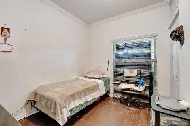 bedroom with hardwood / wood-style floors, ornamental molding, and a textured ceiling